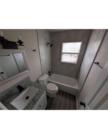 a bathroom with a toilet a sink and mirror