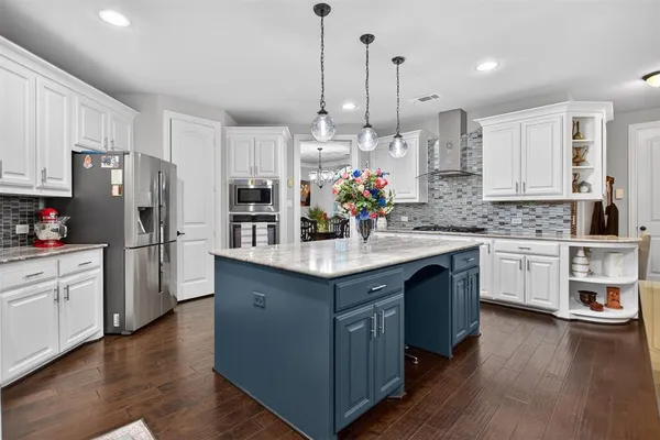 a kitchen with granite countertop a sink cabinets and stainless steel appliances