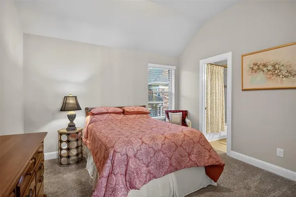 a bed sitting in a bedroom next to a window