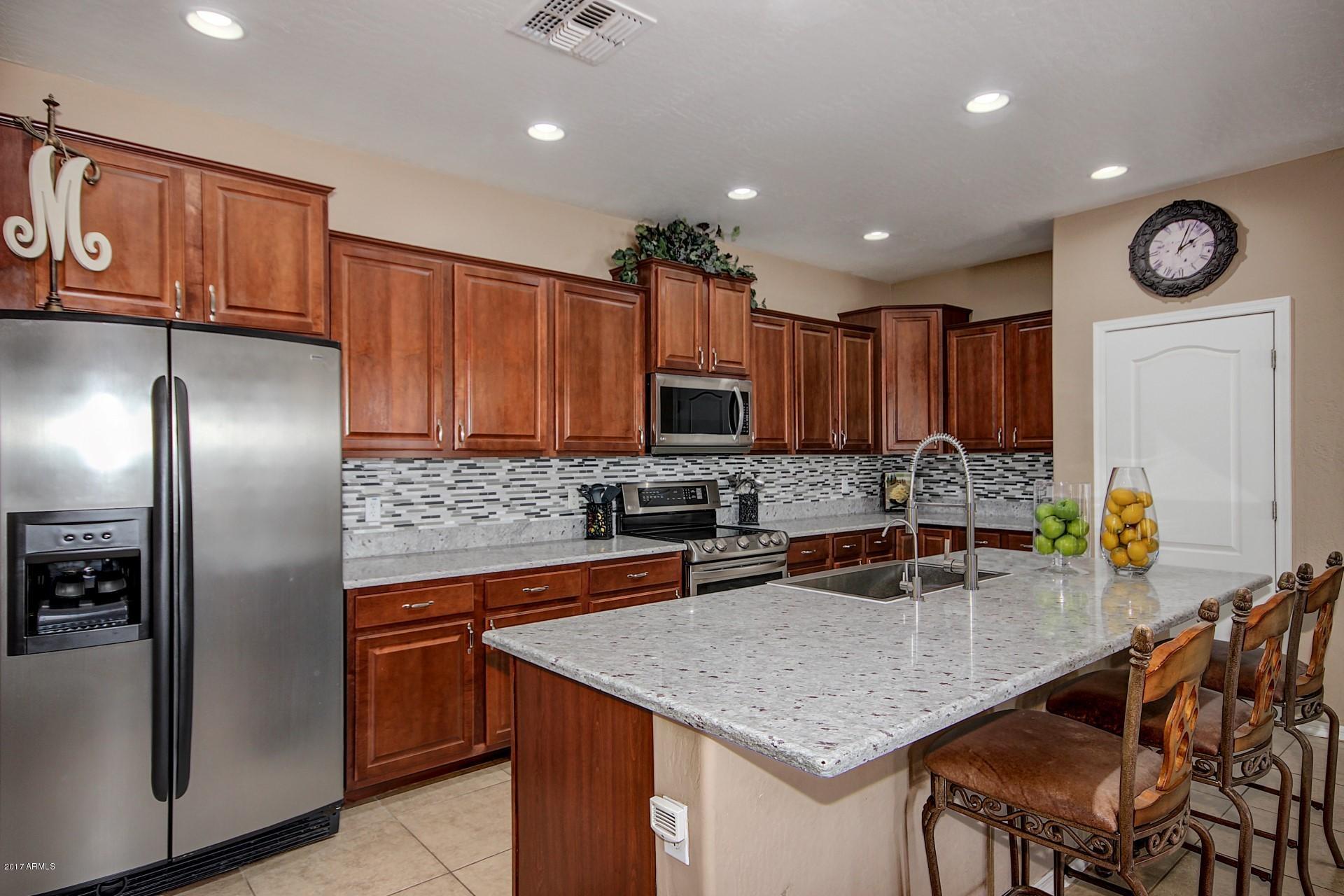21982 East Rosa Road Queen Creek, AZ 85142 - Photo 16 of 40 a kitchen with stainless steel appliances granite countertop a sink refrigerator stove and microwave