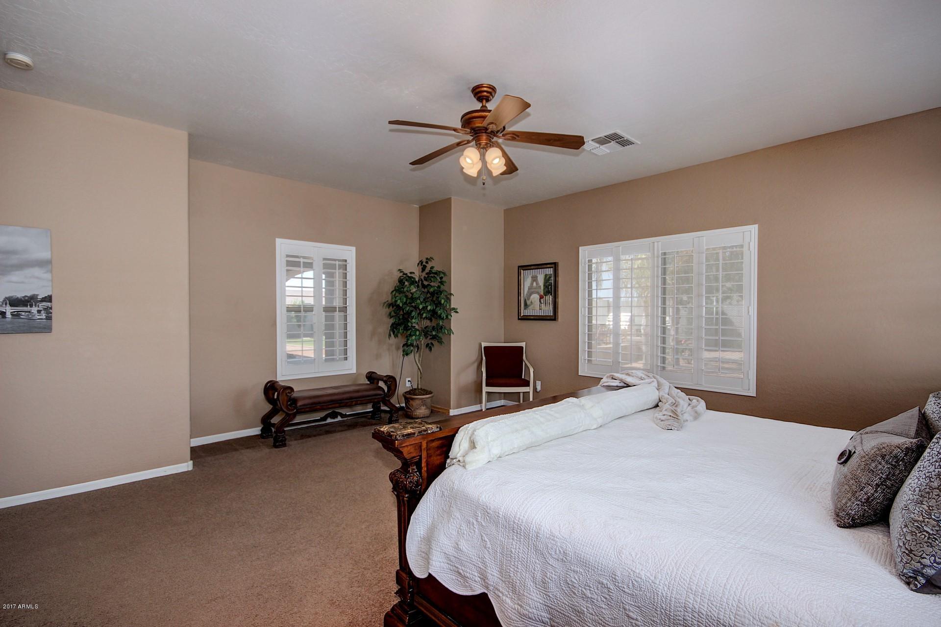 21982 East Rosa Road Queen Creek, AZ 85142 - Photo 28 of 40 a bedroom with a bed and a chandelier