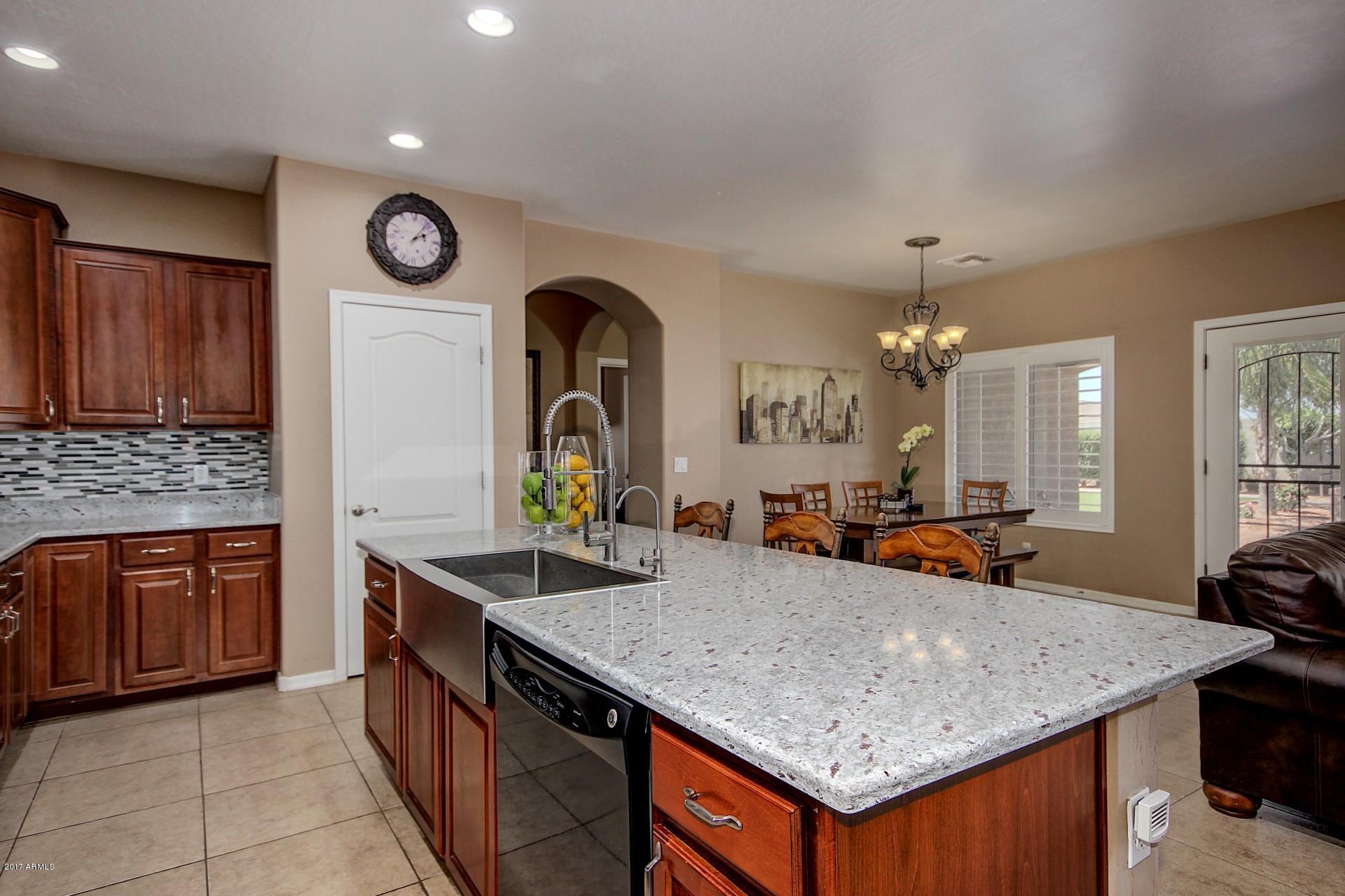 21982 East Rosa Road Queen Creek, AZ 85142 - Photo 3 of 40 a kitchen with stainless steel appliances granite countertop a sink a stove and a wooden cabinets