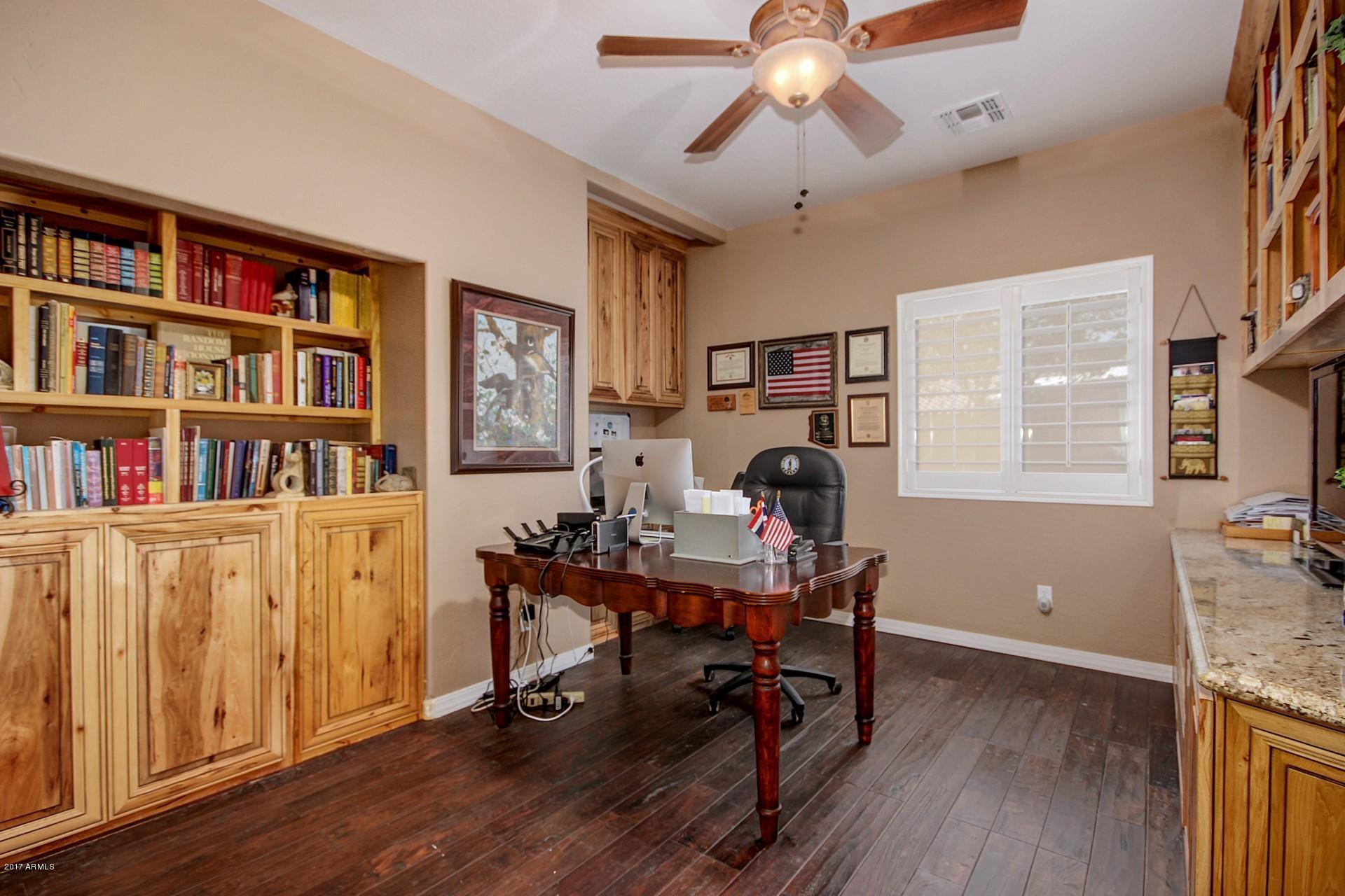 21982 East Rosa Road Queen Creek, AZ 85142 - Photo 5 of 40 a view of a workspace with furniture and a bookshelf