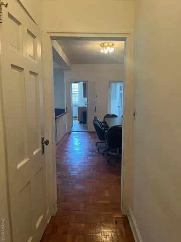a view of a hallway and a livingroom with furniture
