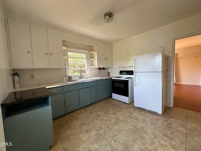 a kitchen with a refrigerator sink and cabinets