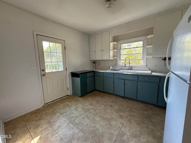 a kitchen with a sink window and cabinets
