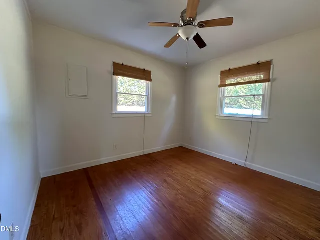 a view of an empty room window and wooden floor