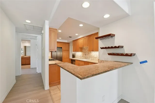 a kitchen with stainless steel appliances granite countertop a sink and a refrigerator