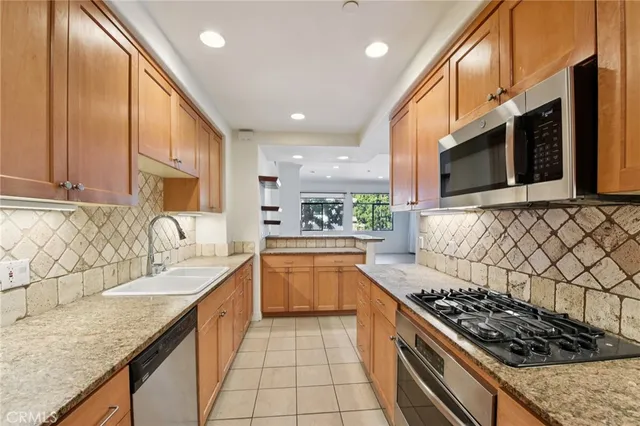 a kitchen with stainless steel appliances granite countertop a sink stove and cabinets