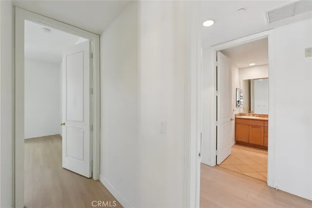 a view of a hallway with a room and a bathroom