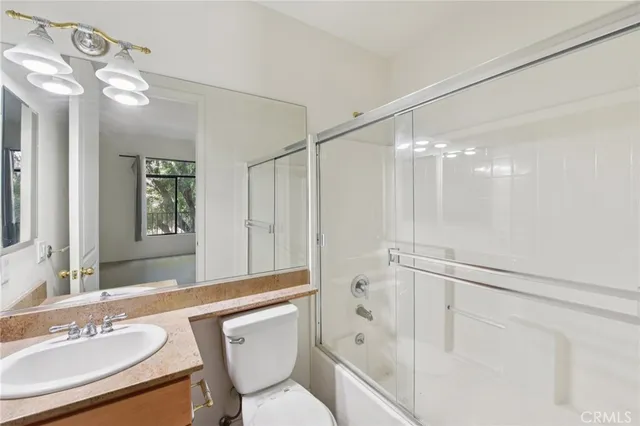 a bathroom with a sink mirror vanity and toilet