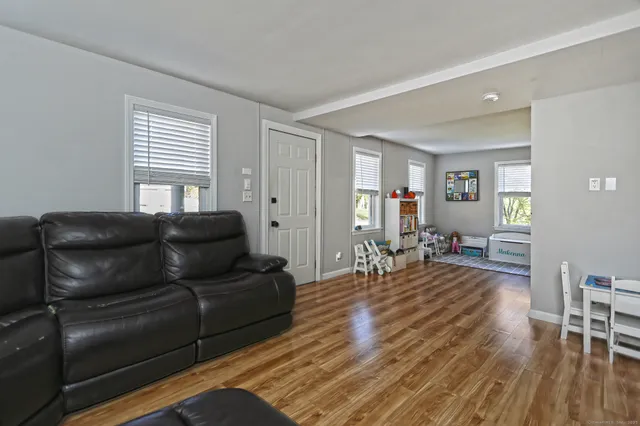 a living room with furniture and a wooden floor