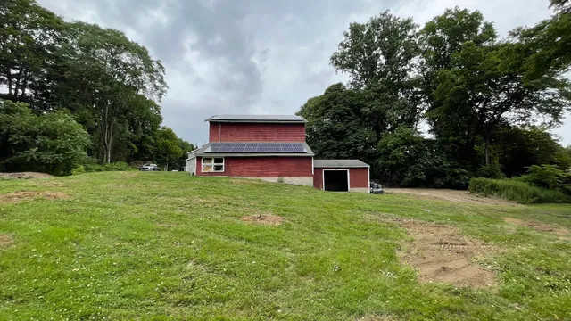 a house is sitting in middle od the grass
