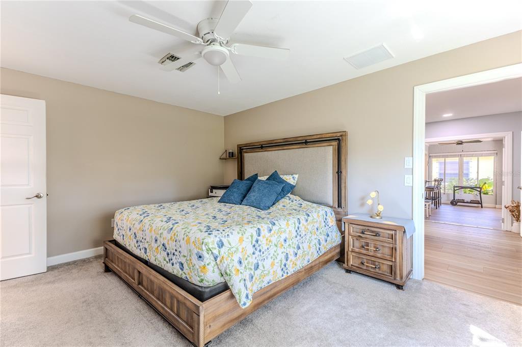 6428 Plantation Road Spring Hill, FL 34606 - Photo 32 of 50 a bedroom with a bed and a chandelier