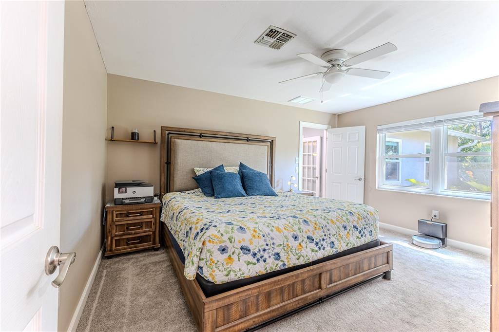6428 Plantation Road Spring Hill, FL 34606 - Photo 33 of 50 a bedroom with a bed and a chandelier