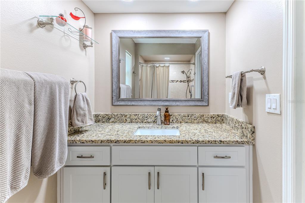 6428 Plantation Road Spring Hill, FL 34606 - Photo 35 of 50 a bathroom with a granite countertop sink and a mirror