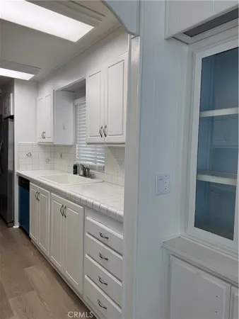 a kitchen with granite countertop white cabinets and white appliances