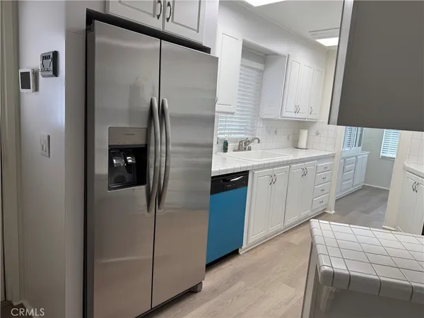 a kitchen with a refrigerator sink and cabinets