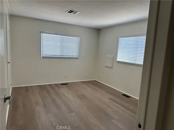 an empty room with wooden floor and a bathroom