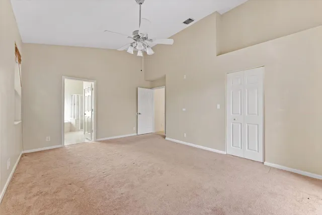 a view of an empty room and chandelier fan