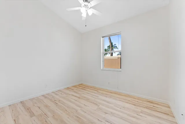 an empty room with a window and wooden floor