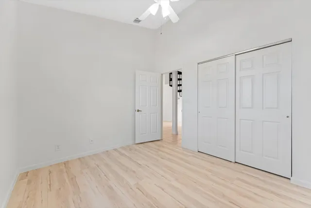 a view of a livingroom with wooden floor and a ceiling fan