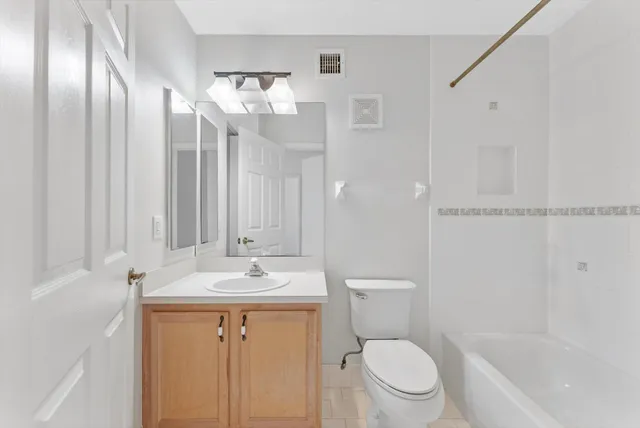 a bathroom with a granite countertop sink toilet and shower