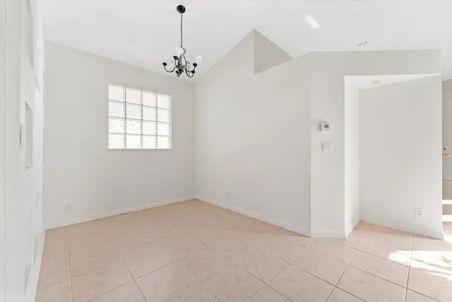 an empty room with chandelier and windows