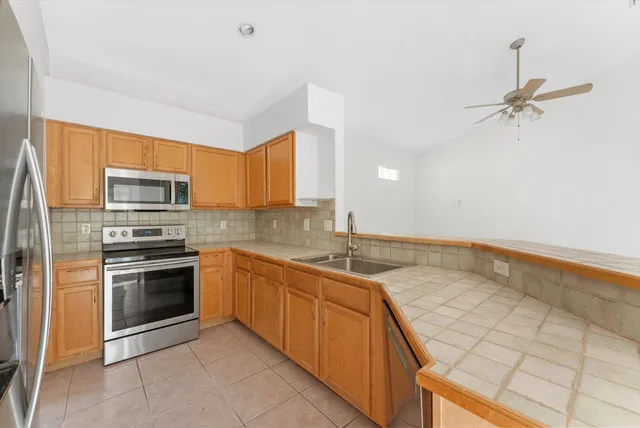 a kitchen with granite countertop stainless steel appliances and wooden cabinets