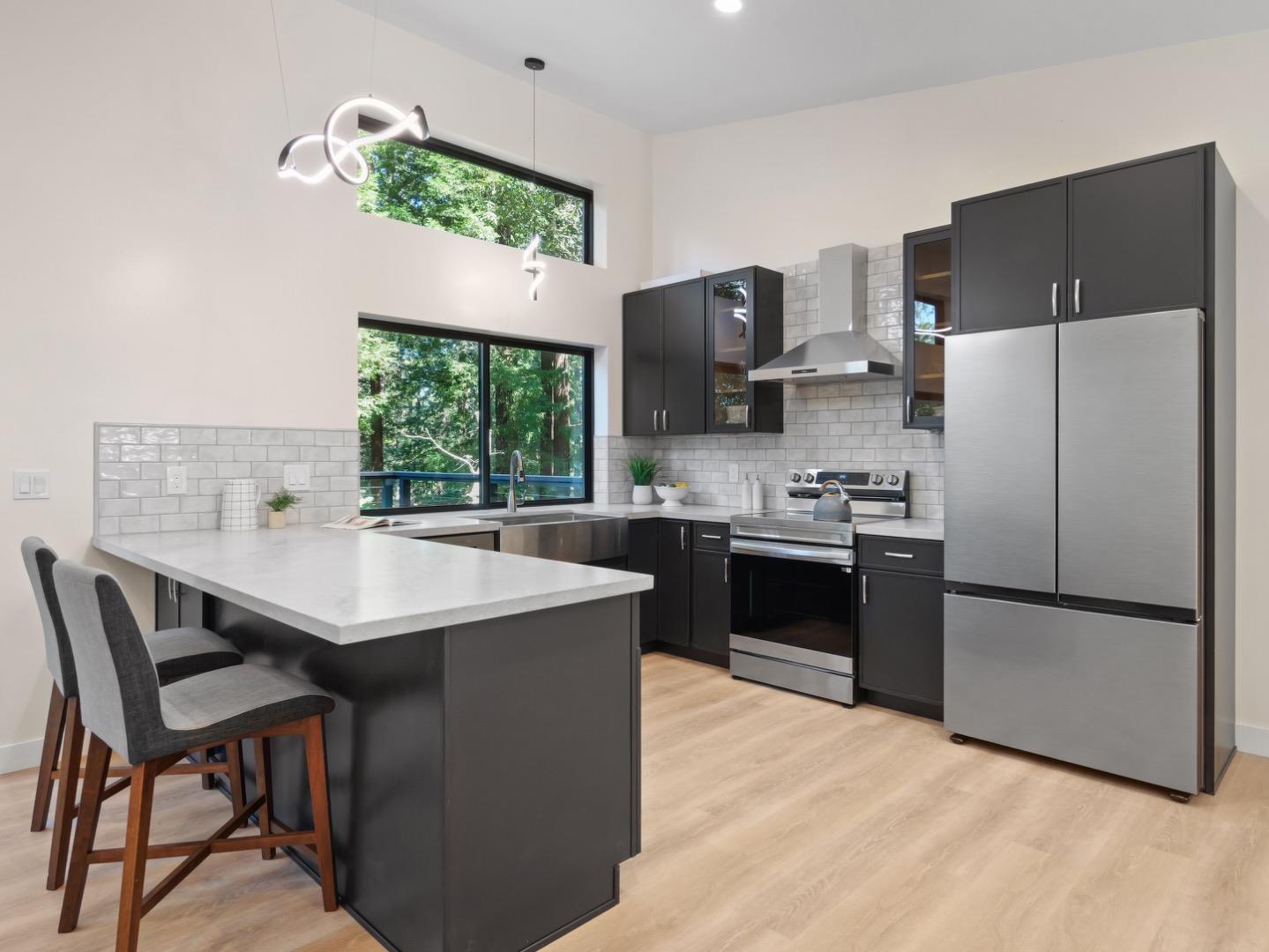 1495 McLellan Road Felton, CA 95018 - Photo 3 of 20 a kitchen with stainless steel appliances a stove a sink dishwasher a refrigerator and a dining table with wooden floor