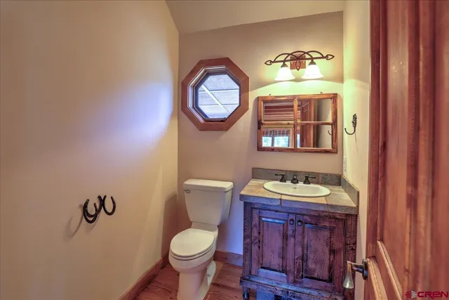 a bathroom with a toilet a sink and a mirror