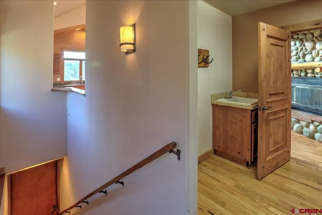 a view of a hallway with wooden floor and staircase