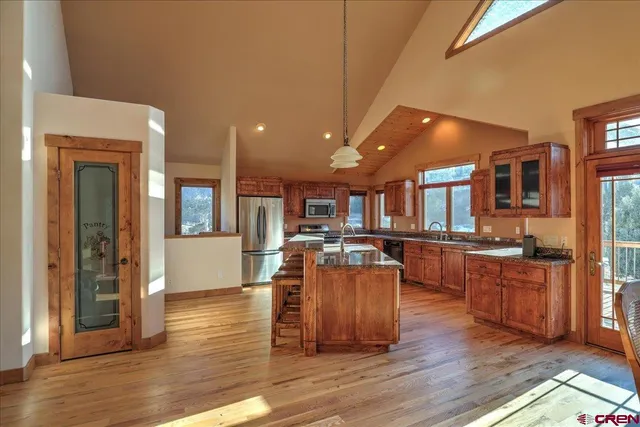 a living room with furniture a wooden floor and a kitchen view