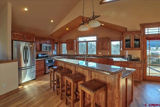 a kitchen with stainless steel appliances granite countertop a sink a stove and a refrigerator