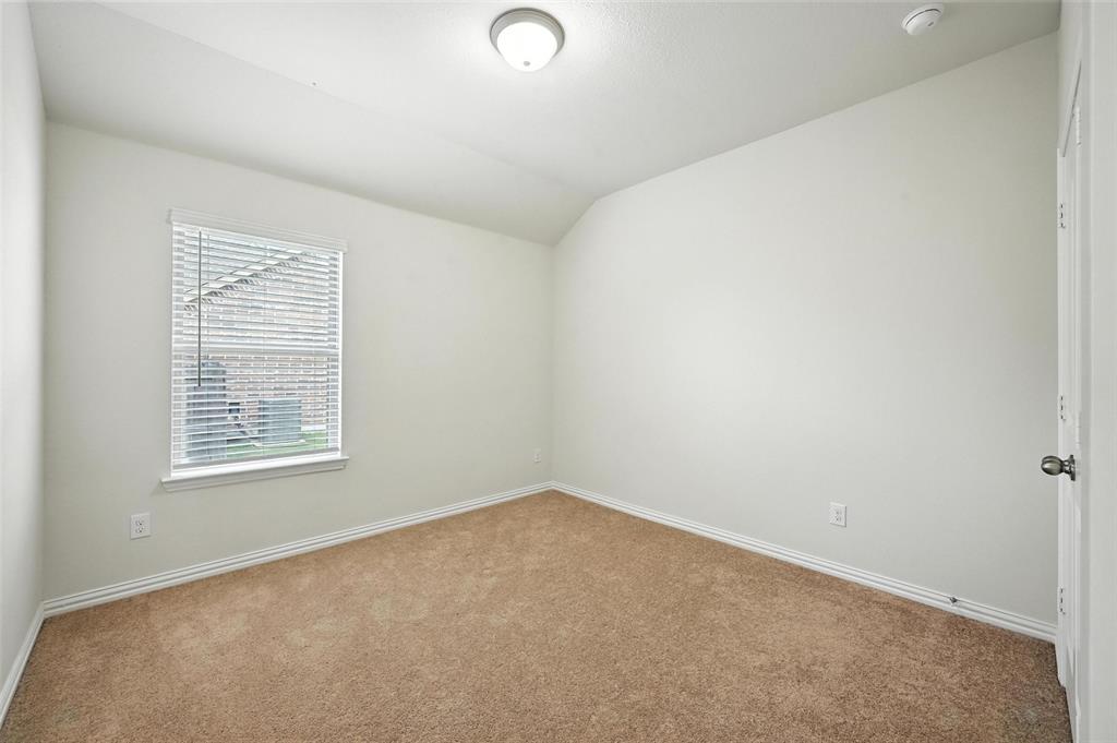 5 Pheasant Run Sanger, TX 76266 - Photo 12 of 27 Carpeted spare room featuring vaulted ceiling and baseboards
