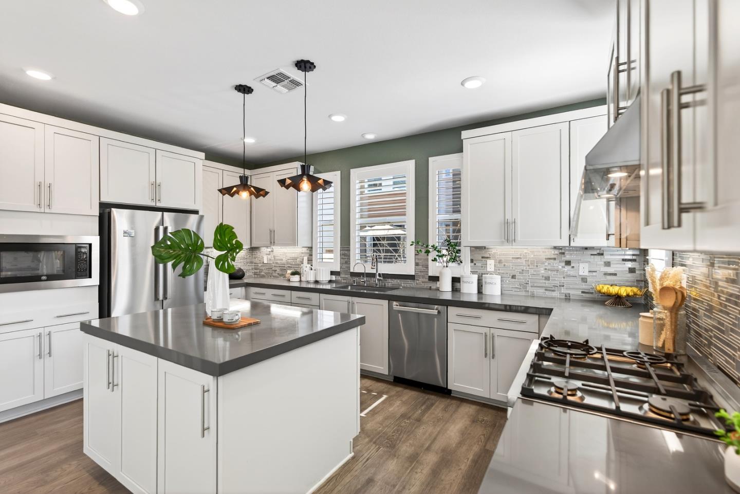 2268 Mora Place Mountain View, CA 94040 - Photo 15 of 38 a kitchen with stainless steel appliances a sink stove and white cabinets with wooden floor