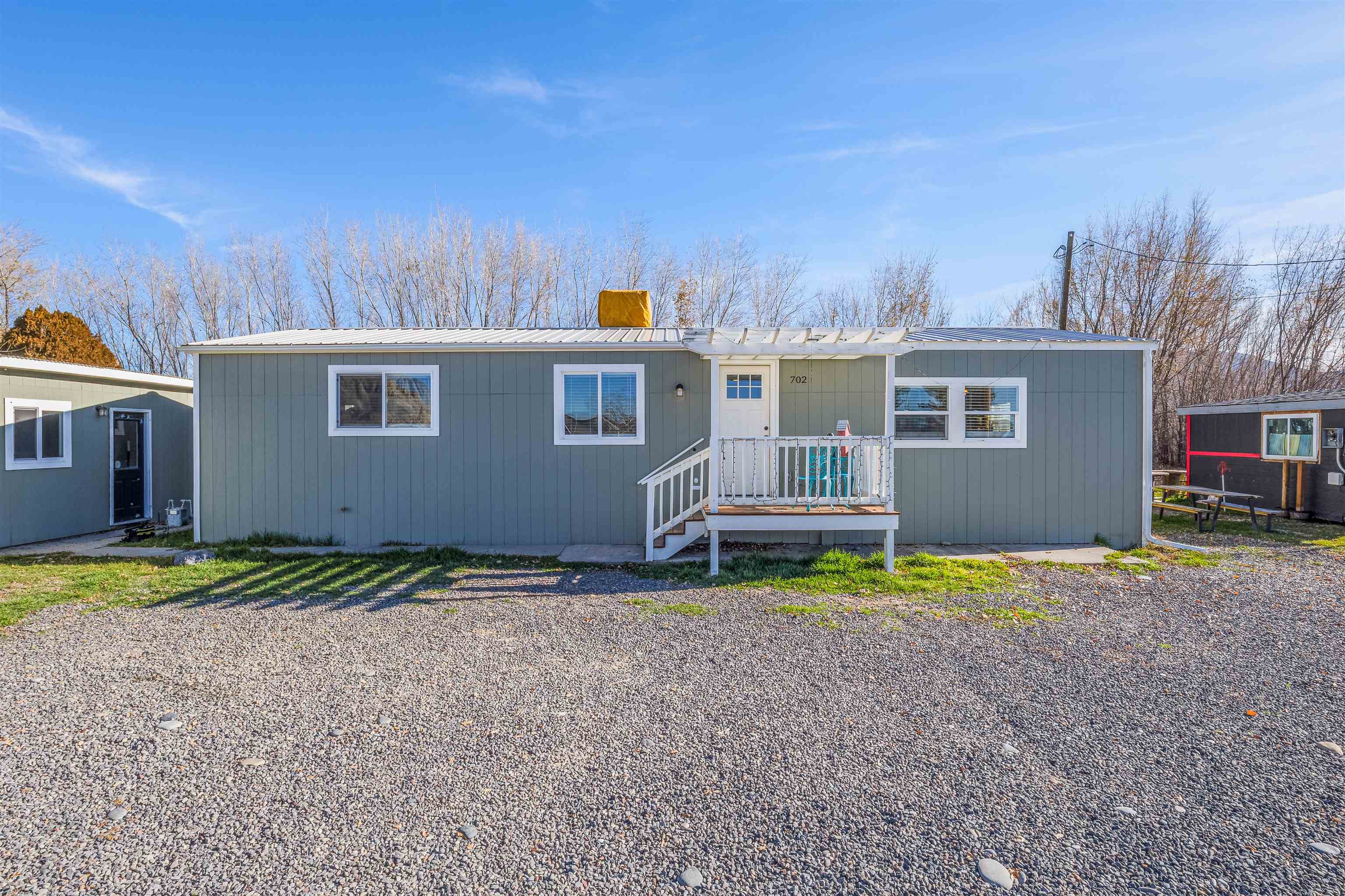 a backyard of a house with barbeque oven and a table and chairs