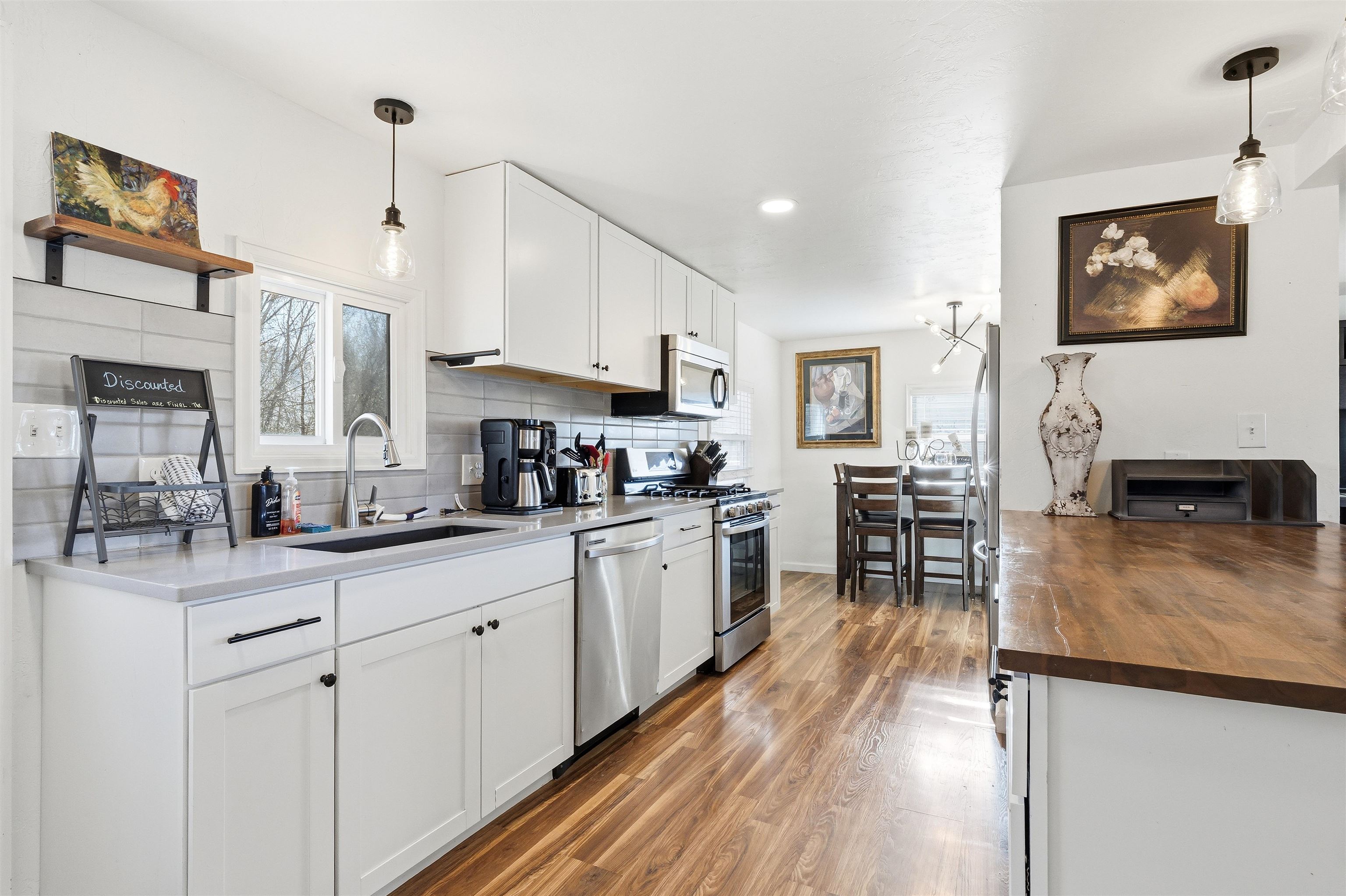 702-37 37 1/10 Road Palisade, CO 81526 - Photo 13 of 42 a kitchen with stainless steel appliances granite countertop a stove top oven a sink a dining table and chairs with wooden floor