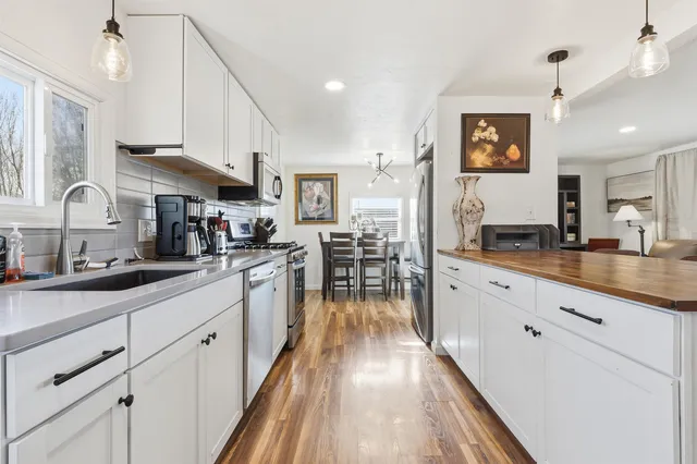 a kitchen with stainless steel appliances granite countertop a sink a stove and cabinets