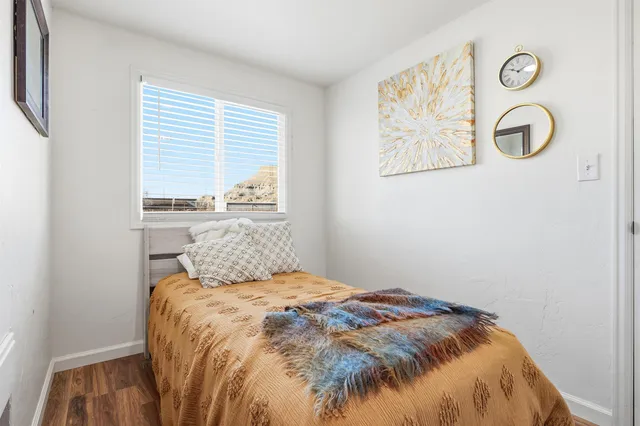 a bedroom with a bed and a painting on the wall