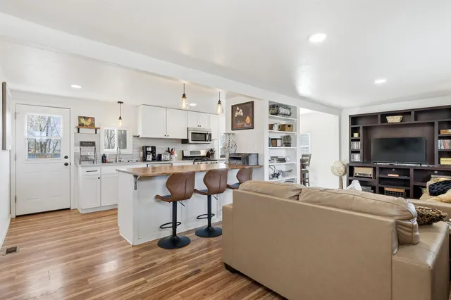 a living room with furniture a flat screen tv and a window