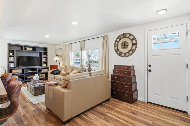 a living room with furniture a flat screen tv and a large window