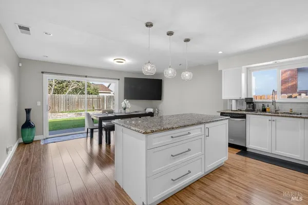 a kitchen with granite countertop stainless steel appliances a sink stove top oven and cabinets