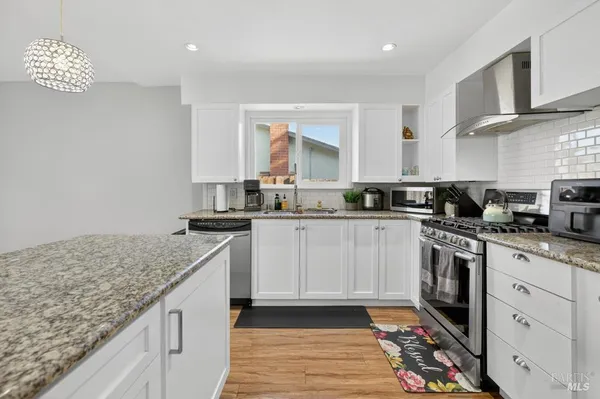 a kitchen with stainless steel appliances granite countertop a sink a stove a microwave and cabinets