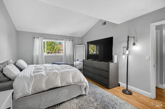 a bedroom with a bed and wooden floor