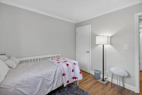 a bedroom with a bed and a flat tv screen on dresser