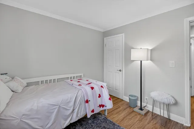 a bedroom with a bed and a flat tv screen on dresser