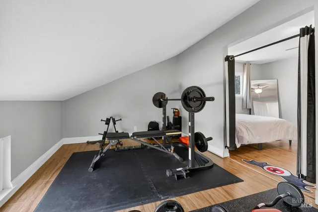 a backyard of a house with table and chairs plants and large tree