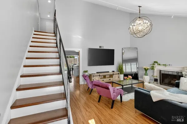 a living room with furniture a flat screen tv and kitchen view