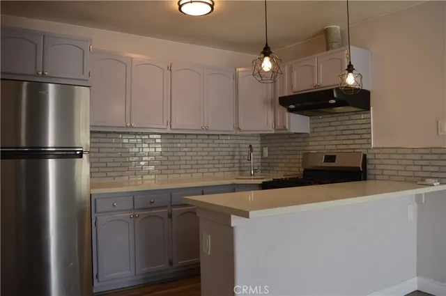 a kitchen with stainless steel appliances granite countertop a sink a refrigerator and a stove